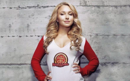 A confident Hayden Panettiere poses against a textured wall, showcasing her talent as an actress, model, and singer, in this striking HD desktop wallpaper.