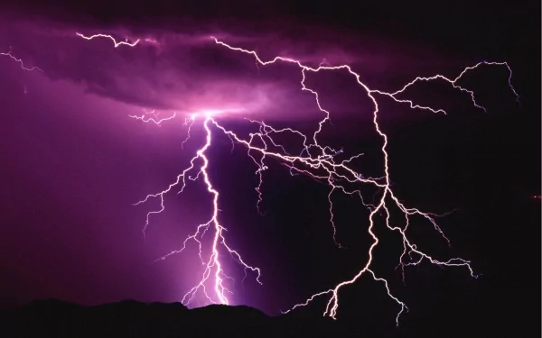 A striking image of lightning illuminating a dark sky, showcasing dramatic purple hues. This HD photograph serves as a captivating desktop wallpaper and background.