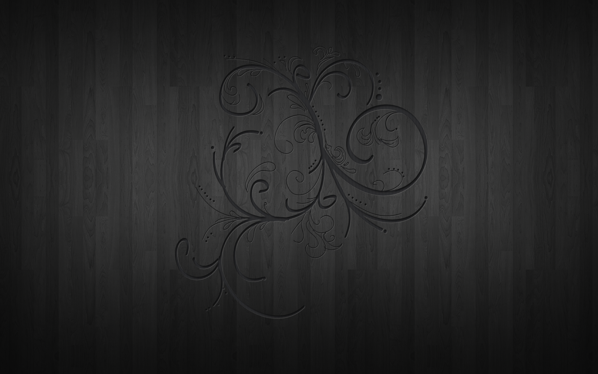 Abstract patterned HD PC desktop wallpaper and background: dark charcoal wood panels with a subtle embossed swirling floral motif centered.