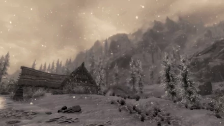 Snow-covered building set against a mountainous winter landscape from The Elder Scrolls V: Skyrim, featured as an HD PC desktop wallpaper and background.