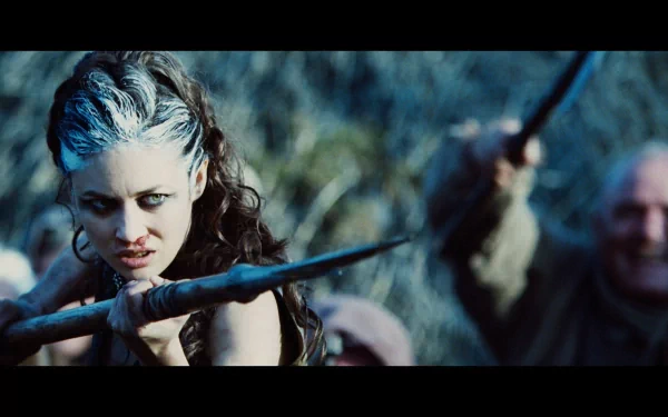 HD PC desktop wallpaper from the movie Centurion, featuring a fierce character gripping a spear in a dark, intense forest setting.