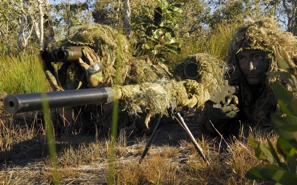 HD desktop wallpaper showing U.S. Army Infantry snipers camouflaged in natural foliage, aiming through a military sniper rifle during wartime.