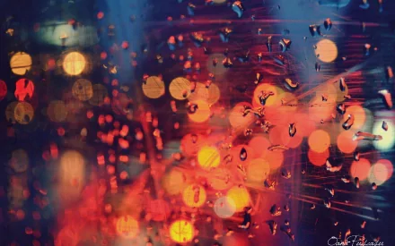 A vibrant, HD desktop wallpaper featuring a close-up of raindrops on glass, creating a beautiful bokeh effect with warm light and reflections in a blend of colors.