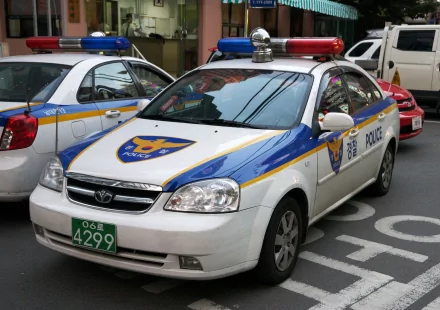 4K Ultra HD PC desktop wallpaper background showing a parked police vehicle — white patrol car with blue and yellow markings and red/blue roof lights
