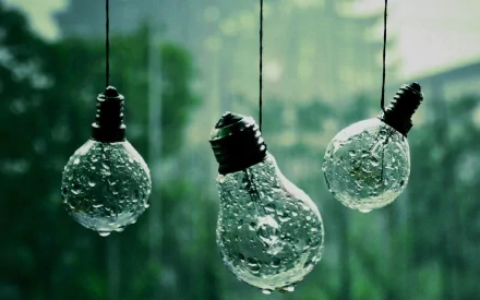 Three light bulbs suspended with droplets of water, set against a soft, green background, create a serene and artistic atmosphere in this HD desktop wallpaper.