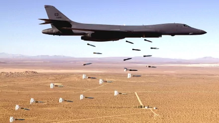 HD PC wallpaper featuring a Rockwell B-1 Lancer bomber releasing ordnance over a desert landscape, highlighting military aviation and aerial strike capabilities.