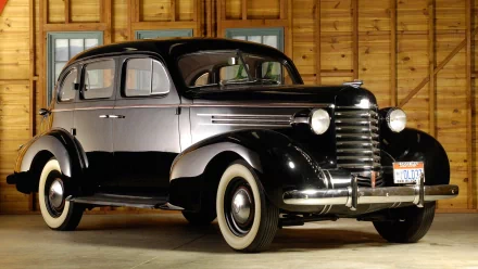 A vintage Oldsmobile with classic rounded design and whitewall tires, showcased indoors as an HD PC desktop wallpaper and background.