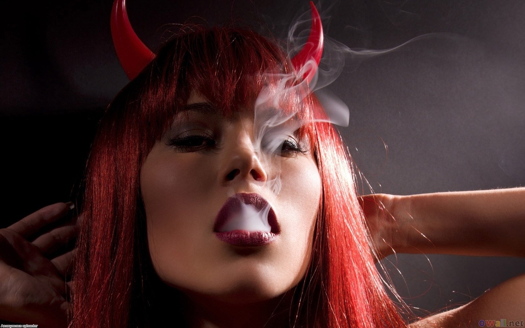 HD desktop wallpaper featuring an artistic close-up of a woman with red lipstick and devil horns, surrounded by swirling smoke against a dark background.