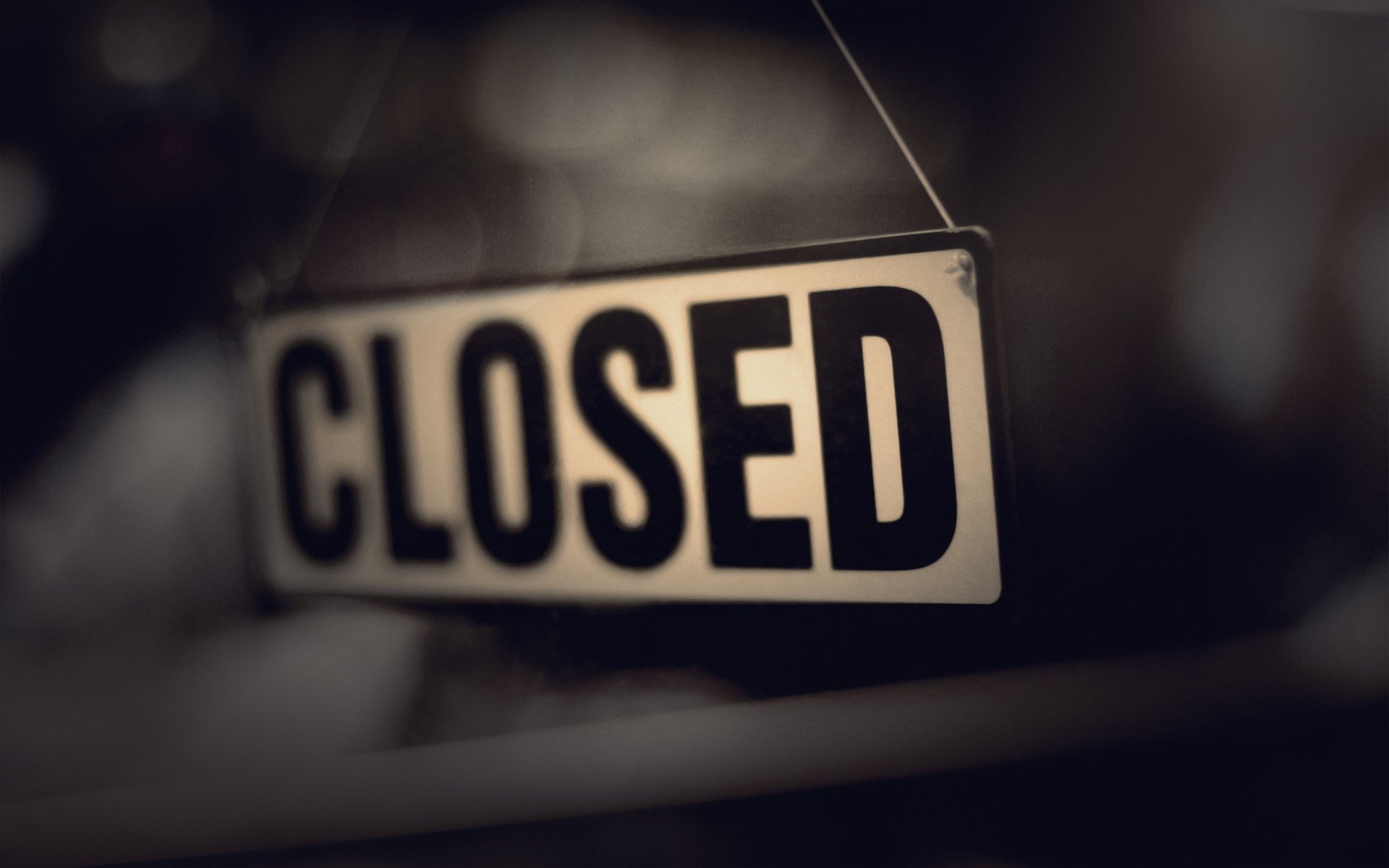 HD PC desktop wallpaper featuring a close-up of a hanging CLOSED sign with a blurred dark background.