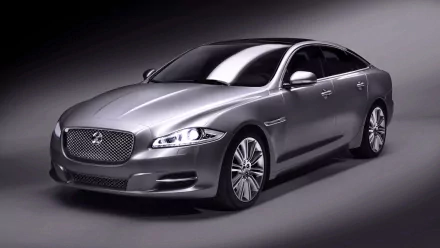 HD desktop wallpaper featuring a sleek silver Jaguar car showcased against a smooth gray background, highlighting its luxury and design.
