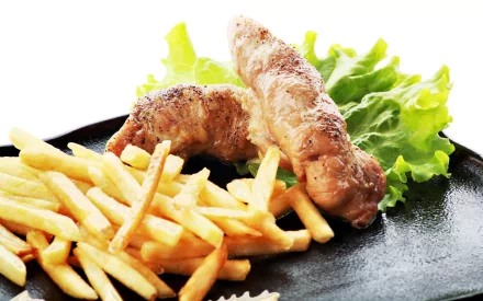 2K Quad HD PC desktop wallpaper background showing a plated meal: grilled sausages, golden French fries and crisp lettuce.