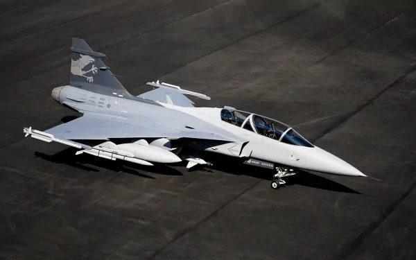 A high-definition desktop wallpaper featuring a sleek military jet fighter, showcasing its advanced design and distinct camouflage patterns on a runway background.