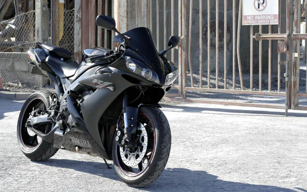 Yamaha sport motorcycle parked on a sunlit street — HD PC desktop wallpaper and background showing the vehicle from a low front-side angle.