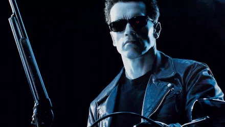 HD desktop wallpaper featuring Arnold Schwarzenegger as The Terminator from the movie Terminator 2: Judgment Day, wearing sunglasses and a leather jacket, with a gun in hand.