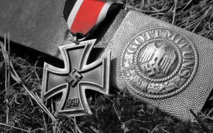 HD PC desktop wallpaper: black-and-white close-up of military medals — Iron Cross and Gott mit uns belt buckle with swastikas resting on grass.