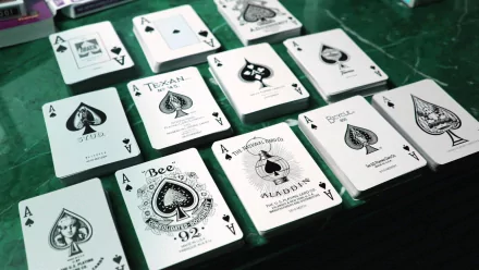 A vibrant HD PC desktop wallpaper featuring various playing cards, prominently displaying the ace of spades in unique designs on a green surface.