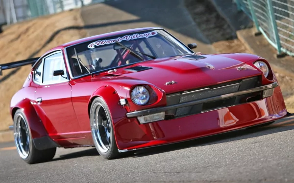 HD PC desktop wallpaper featuring a sleek red sports car parked on a racetrack, showcasing its aerodynamic design and polished finish.
