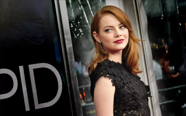 Emma Stone poses elegantly in a black lace dress against a sleek backdrop, showcasing her signature style in this HD desktop wallpaper and background.