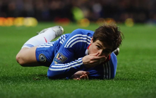 HD PC desktop wallpaper and background: sports photo of a footballer in a blue kit lying on the pitch, hand over his mouth, captured mid-match.