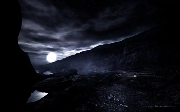 HD desktop wallpaper from the video game Dear Esther, featuring a dark, moonlit coastal landscape with rocky shores and misty hills under a cloudy sky.