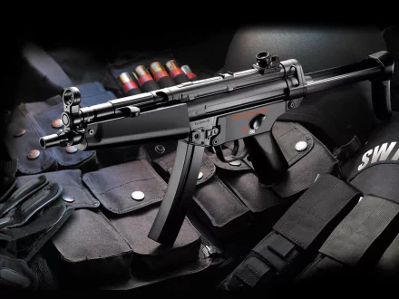 A high-definition desktop wallpaper featuring a Heckler & Koch MP5 submachine gun, displayed alongside magazines and tactical gear. The image captures the intricate design of this man-made firearm.