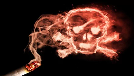 A striking HD wallpaper featuring a dark background with smoke forming a skull shape, emphasizing themes of smoking and danger.