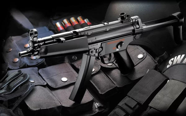 A high-definition desktop wallpaper featuring a Heckler & Koch MP5 submachine gun, displayed alongside magazines and tactical gear. The image captures the intricate design of this man-made firearm.