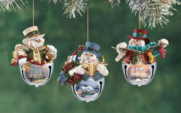 HD desktop wallpaper featuring three festive Christmas ornaments depicting snowmen on silver bells, set against a green holiday background.