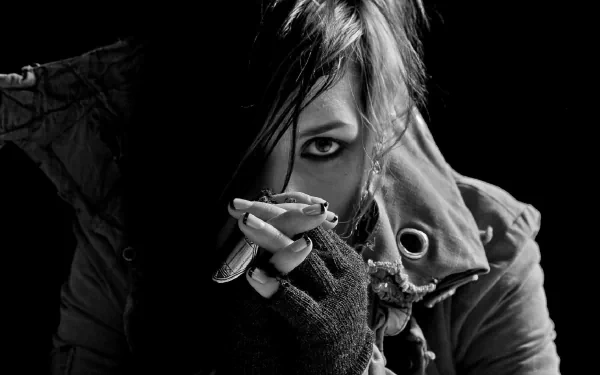 A striking black-and-white portrait of Noomi Rapace, showcasing her intense gaze and edgy style, set against a dark background, with artistic elements reminiscent of Skylar Grey's music.