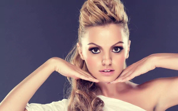 HD desktop wallpaper and background featuring Alexandra Stan with hands framing her face, embodying a stylish and confident music theme.