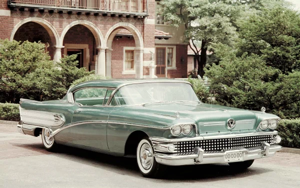 A classic green car parked in front of an elegant building, showcasing vintage design details. An appealing HD wallpaper for car enthusiasts and retro lovers.