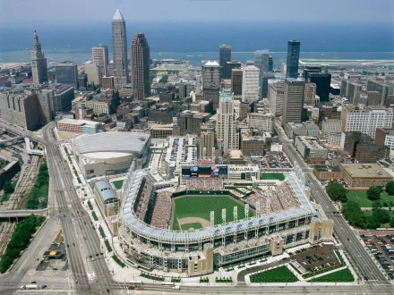 Aerial HD desktop wallpaper of Progressive Field in downtown Cleveland, Ohio, showing the man-made ballpark and surrounding city skyline along Lake Erie.