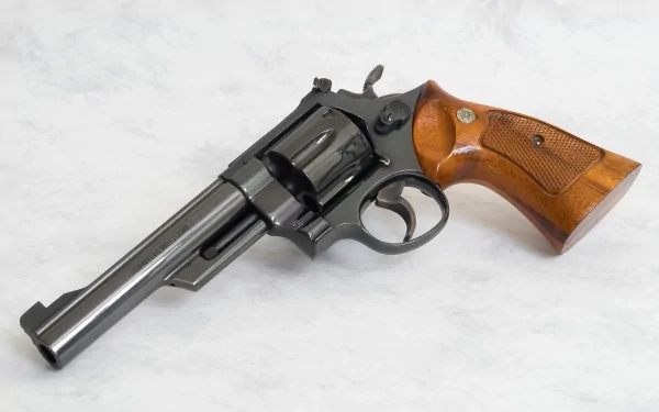 HD desktop wallpaper featuring a detailed man-made Smith & Wesson revolver with a black metal frame and wooden grip on a neutral background.