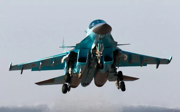 Military Sukhoi Su-34 fighter-bomber, landing gear extended against a pale sky — HD PC desktop wallpaper/background.