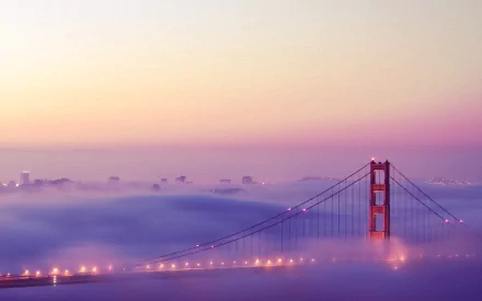 2K Quad HD PC desktop wallpaper: man-made Golden Gate Bridge emerging from soft morning fog with city skyline faintly visible.
