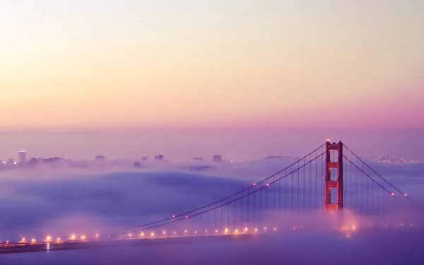2K Quad HD PC desktop wallpaper: man-made Golden Gate Bridge emerging from soft morning fog with city skyline faintly visible.