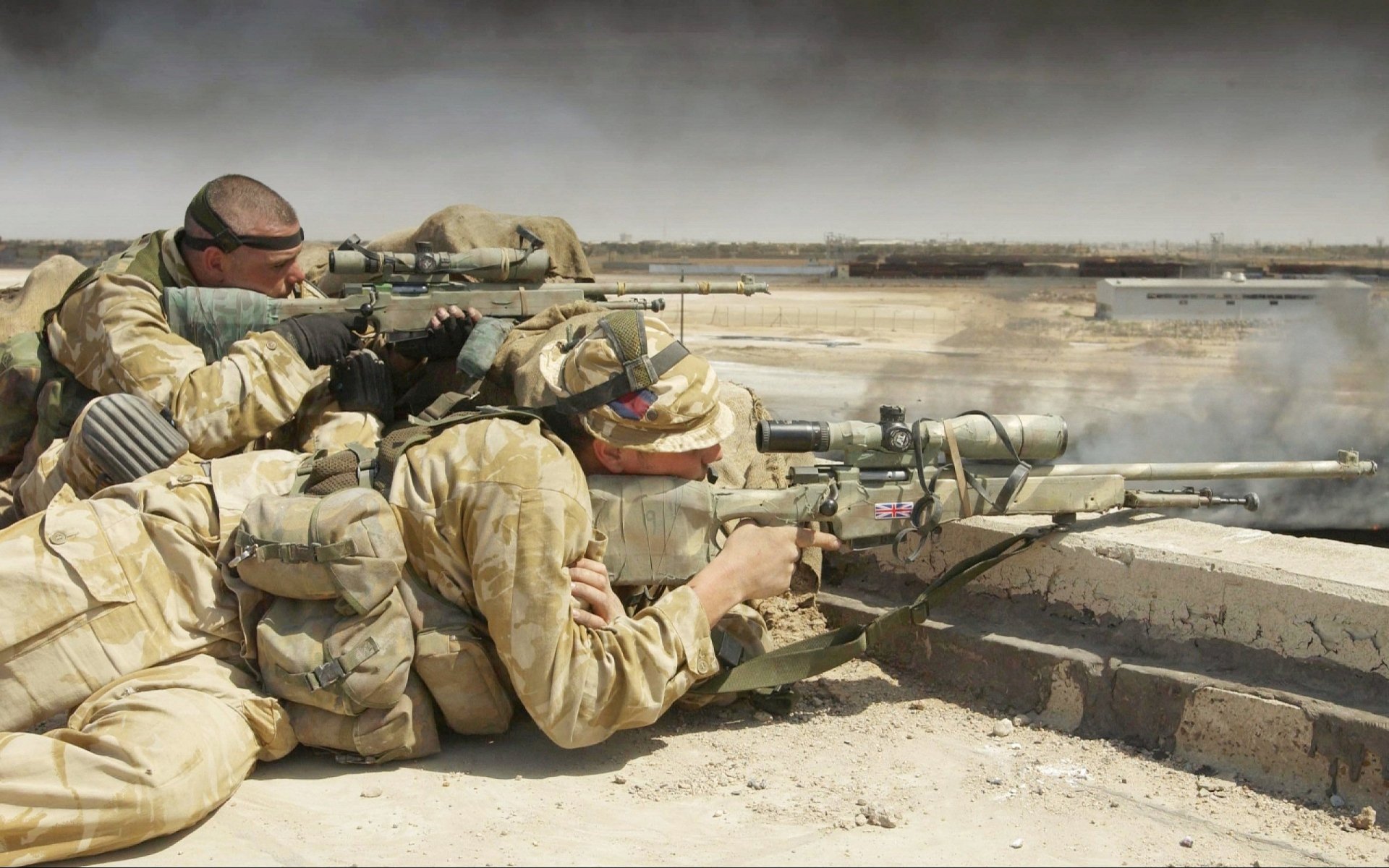U.S. Army infantry and British military snipers, armed and camouflaged, aim their rifles during a war. This HD wallpaper captures the intense focus and coordination on the battlefield.