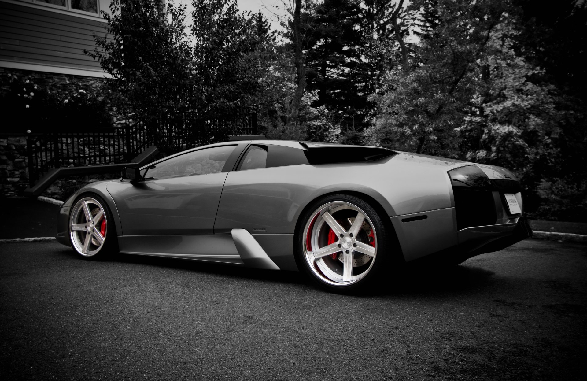 Gray Lamborghini Murcielago parked by trees, dramatic high-contrast 4K Ultra HD PC desktop wallpaper/background showcasing sleek lines and red brake calipers.