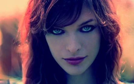 A striking HD desktop wallpaper featuring celebrity Milla Jovovich, showcasing her captivating gaze and charismatic presence amidst a colorful backdrop.