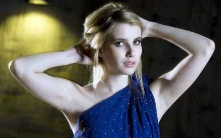 A striking HD wallpaper featuring actress Emma Roberts, showcasing her blonde hair and elegant blue attire, set against a dramatic backdrop.