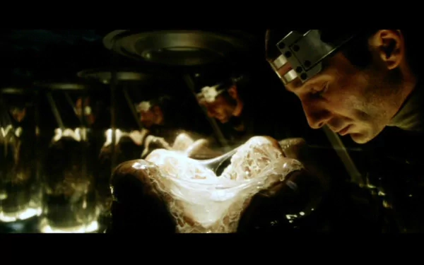 HD PC desktop wallpaper from Alien: Resurrection: a scientist in a dim lab examines a translucent alien egg amid reflective tanks and eerie green lighting.