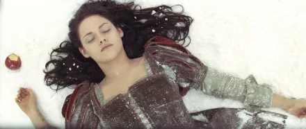 Kristen Stewart as Snow White lying in the snow, from the movie Snow White and the Huntsman, featured in an HD PC desktop wallpaper.