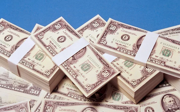HD PC desktop wallpaper featuring stacks of man-made U.S. dollar bills against a clear blue background.