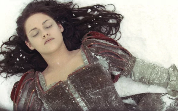 Kristen Stewart as Snow White lying in the snow, from the movie Snow White and the Huntsman, featured in an HD PC desktop wallpaper.
