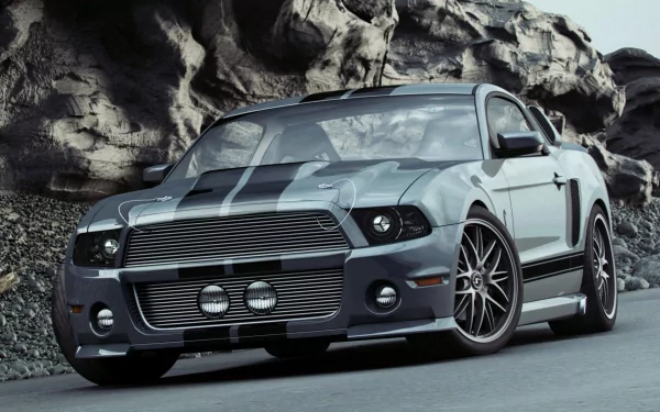 HD PC desktop wallpaper featuring a sleek Ford Mustang Shelby GT500 parked against a rugged rocky backdrop, showcasing its aggressive design and sporty appeal.