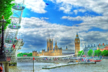 A vibrant HDR view of the London Eye by the River Thames, showcasing Big Ben and the Houses of Parliament against a dramatic sky, capturing the essence of London, England.