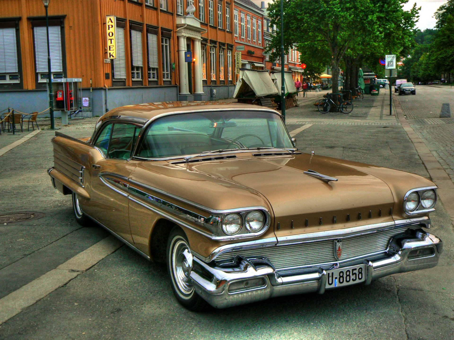 HD PC desktop wallpaper featuring a vintage Oldsmobile parked on a city street, showcasing classic automotive design and chrome details.