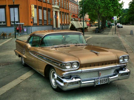 HD PC desktop wallpaper featuring a vintage Oldsmobile parked on a city street, showcasing classic automotive design and chrome details.