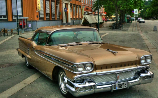 HD PC desktop wallpaper featuring a vintage Oldsmobile parked on a city street, showcasing classic automotive design and chrome details.
