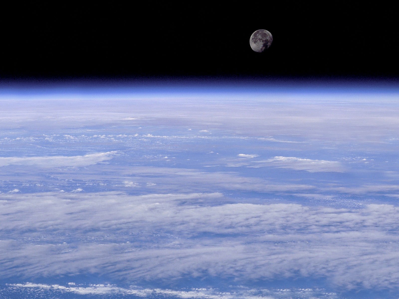 A stunning HD desktop wallpaper showcasing a planet and clouds against a deep space backdrop, featuring the moon quietly hovering above in a Sci-Fi atmosphere.